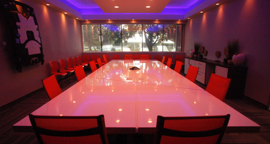 Conference room, custom table with high gloss, Solicore plastic laminate with reveals throughout the table - reflecting their corporate theme in the space. Includes plastic laminate credenza and countertops to match.