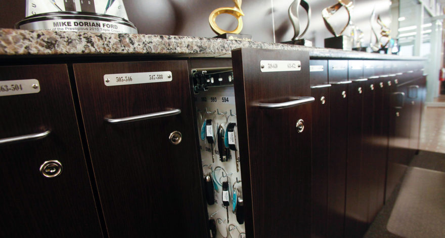 Custom plastic laminate locking key storage cabinets with granite countertop.