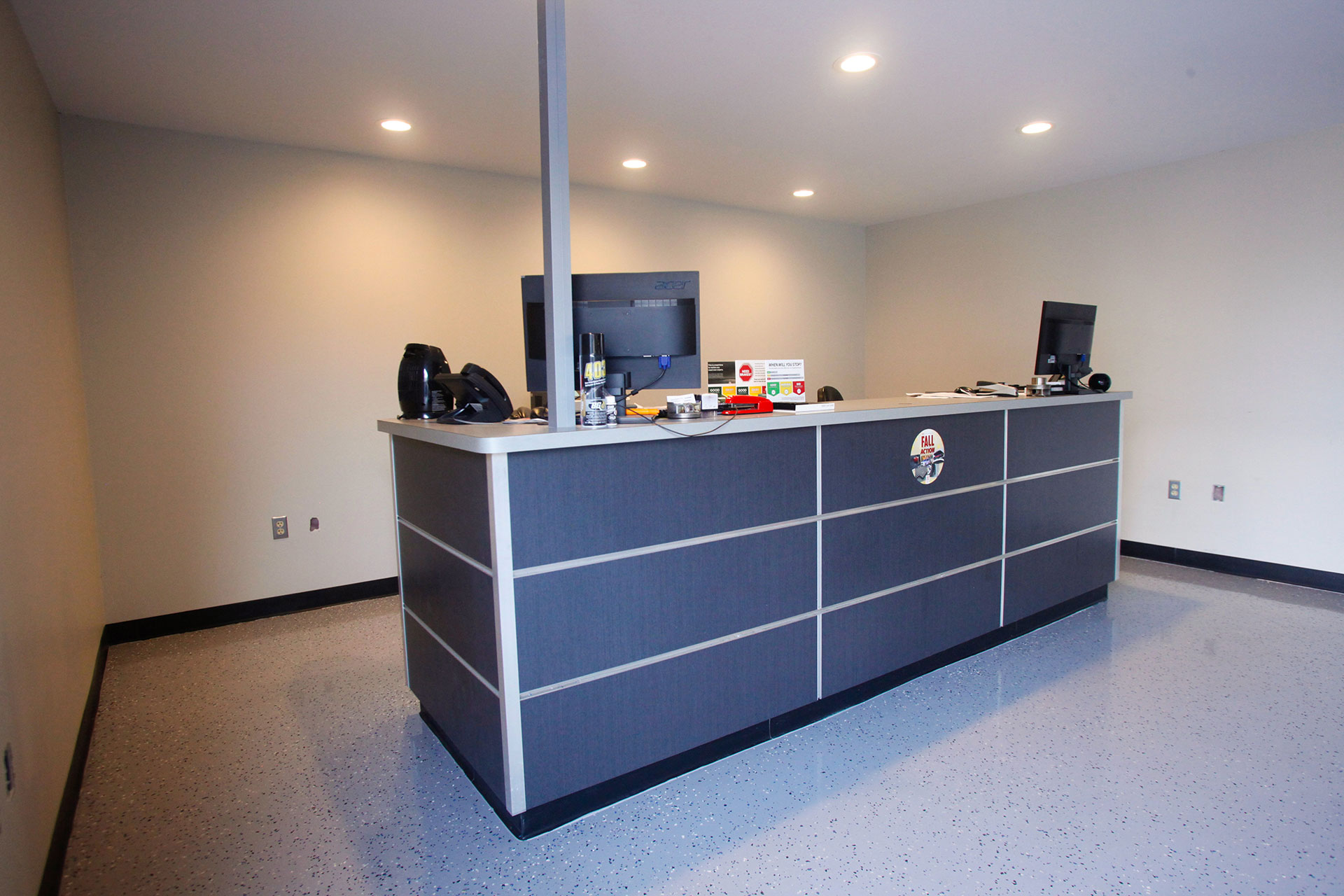 Custom plastic laminate reception/check out desk with plastic laminate partial-height wall with metal reveals and trim and plastic laminate countertop.