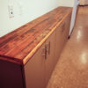 Plastic laminate base cabinets with reclaimed wood flooring countertops.